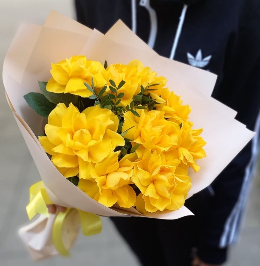 Желтые кружевные розы с зеленью в упаковке